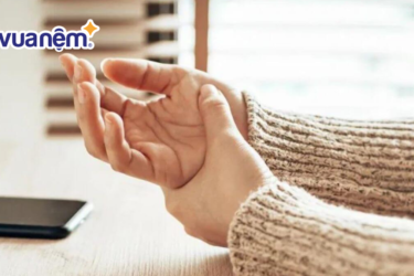 Tại sao ngủ dậy bị tê tay? Ngủ dậy bị tê tay là tình trạng rất phổ biến hiện nay và bất cứ ai cũng có thể gặp phải. Nó có thể là dấu hiệu của việc bạn nằm sai tư thế, bị tì, đè quá lâu khi ngủ nhưng nó cũng có thể là biểu hiện cho thấy sức khỏe của bạn đang gặp vấn đề. Và để chắc chắn về tình trạng ngủ dậy bị tê tay hiện tại của bạn (hoặc người thân) là do nguyên nhân nào gây ra, hãy cùng Vua Nệm tìm hiểu chi tiết trong bài viết dưới đây. 1. Hiện tượng tê tay là gì? Tê tay là tình trạng một vùng hoặc toàn bộ cánh tay gặp phải tình trạng tê bì, râm ran như bị kiến bò, mũi kim tiêm chích, thậm chí là mất cảm giác trong một khoảng thời gian nhất định. Tình trạng này xảy ra do dây thần kinh bị tác động, chèn ép quá lâu gây nên. Tùy thuộc vào mức độ, tần suất và thời gian bị tê tay mà bạn có thể đánh giá được tình trạng này là nặng hay nhẹ và có cần đi khám để điều trị kịp thời hay không. Cụ thể như sau: Nếu thỉnh thoảng bạn bị tê tay sau khi ngủ dậy và 1 lát sau hiện tượng này tự biến mất, không gây ảnh hưởng đến công việc và các hoạt động thường ngày, thì bạn có thể hoàn toàn yên tâm. Bởi, đây là tình trạng tê tay sinh lý, và không có gì đáng lo ngại. Nếu tình trạng tê tay sau khi ngủ dậy diễn ra thường xuyên trong một thời gian dài, và kéo dài trong một ngày thì bạn cần theo dõi kỹ hơn và đến ngay các cơ sở y tế chuyên khoa để khám và điều trị kịp thời. Bởi, rất có thể đây là dấu hiệu cho thấy bạn đang mắc các bệnh lý khác, có ảnh hưởng tiêu cực đến sức khỏe. Tê nhức bàn tay Và để biết được tình trạng tê tay hiện tại của bạn là do nguyên nhân nào: sinh lý hay bệnh lý, hãy theo nó trong một khoảng thời gian nhất định. 2. Tại sao ngủ dậy bị tê tay - Những nguyên nhân chính dẫn tới việc ngủ dậy bị tê tay Với những phân tích phía trên, có thể việc tại sao ngủ dậy bị tê tay sẽ xuất phát từ 1 trong 2 nhóm nguyên nhân chính là: nguyên nhân sinh lý và nguyên nhân bệnh lý. Trong đó: 2.1. Nhóm nguyên nhân bệnh lý Với nhóm này, tình trạng tê tay sẽ xảy ra thường xuyên và kéo dài hơn, ảnh hưởng đến chất lượng cuộc sống và công việc của bạn. Đây cũng là dấu hiệu phản ánh tình trạng sức khỏe hiện tại của bạn tốt hay xấu. Nhóm nguyên nhân bệnh lý có thể xuất phát từ 1 trong số những lý do dưới đây: 2.1.1. Các bệnh về xương khớp Khi bị các bệnh về thoái hóa đốt sống, thoát vị đĩa đệm, phần đốt sống thường xuyên chèn ép lên các dây thần kinh, gây ra tình trạng tê bì tay chân, ảnh hưởng đến khả năng sinh hoạt và vận động của người bệnh. 2.1.2. Cơ thể thiếu chất dinh dưỡng Tại sao ngủ dậy bị tê tay - Cơ thể bị thiếu các chất dinh dưỡng Vitamin và khoáng chất là những chất dinh dưỡng cần thiết để duy trì sức khỏe và hệ thống dây thần kinh được khỏe mạnh. Do đó, khi thiếu hụt các chất này sẽ gây ra tình trạng tê cứng cơ thể và tê bì tay chân. Những triệu chứng bạn có thể gặp phải khi thiếu chất dinh dưỡng như: mệt mỏi, không tập trung, khó tỉnh táo, đuối sức, khó giữ được thăng bằng, vàng da,… 2.1.3. Do các tác dụng phụ của thuốc Khi sử dụng một số loại thuốc đặc trị như: thuốc chống động kinh, thuốc ngăn ngừa ung thư, thuốc điều trị tim, thuốc điều hòa huyết áp, thuốc kháng sinh,… một số người sẽ bị tác dụng phụ của thuốc gây nên tổn thương về thần kinh, từ đó làm tê bì tay chân. 2.1.4. Hội chứng ống cổ tay Hội chứng ống cổ tay là tình trạng các mô xung quanh dây thần kinh ở ống cổ tay bị phồng lên và gây áp lực lại lên dây thần kinh, khiến tình trạng tê mỏi xuất hiện. Hội chứng này bắt nguồn từ việc bạn thường xuyên dùng tay để lặp đi lặp lại các hành động liên tục như: gõ phím, làm việc theo dây chuyền lắp ráp,… 2.1.5. Do tiểu đường Với những người mắc bệnh tiểu đường, hàm lượng đường trong máu cao gây tổn thương thần kinh, tạo nên những hiện tượng tê bì tay chân, xương khớp. Ngoài ra, nó còn có thêm các triệu chứng như: đuối sức, mất thăng bằng, hoa mắt chóng mặt, giảm thị lực,… Tại sao ngủ dậy bị tê tay - Do biến chứng của tiểu đường gây nên 2.1.6. Chứng rối loạn tuyến giáp Tuyến giáp có chức năng sản xuất ra các hormone dùng để tham gia vào quá trình trao đổi chất của cơ thể. Khi tuyến giáp bị rối loạn tức là chức năng này kém đi, làm tổn thương các dây thần kinh và gây ra tình trạng tê nhức tay chân. 2.1.7. Bệnh thần kinh liên quan đến bia rượu Rượu bia là chất kích thích có tác động không tốt, gây tổn hại đến các dây thần kinh của cơ thể khi người dùng sử dụng quá nhiều. Do đó, rất nhiều người gặp phải tình trạng tê tay sau một thời gian dài sử dụng quá nhiều rượu bia. 2.1.8. Hội chứng lối thoát lồng ngực Hội chứng lối thoát lồng ngực xảy ra khi các mạch máu hoặc dây thần kinh vùng cổ – vai – ngực bị chèn ép, đặc biệt là tại khu vực giữa xương đòn và xương sườn. Khi ngủ sai tư thế, như gối đầu quá cao hoặc vắt tay lên đầu quá lâu, các vùng này càng dễ bị đè nén, dẫn đến tình trạng tê, đau lan xuống cánh tay và bàn tay sau khi thức dậy. Người bị hội chứng này thường cảm thấy cánh tay nặng nề, mỏi mệt và đôi khi tê như kiến bò kéo dài. 2.1.9. Bệnh thần kinh ngoại biên Thần kinh ngoại biên là mạng lưới dây thần kinh phân bố khắp cơ thể, điều khiển cảm giác và vận động của tay chân. Khi các dây thần kinh này bị tổn thương – do thiếu vitamin B12, nhiễm độc hoặc do tuổi tác – người bệnh rất dễ bị tê tay, nhất là khi ngủ dậy. 2.1.10. Dây thần kinh bị chèn ép Một tư thế ngủ sai lệch, nằm đè lên tay quá lâu, hoặc sử dụng gối quá cao, cứng cũng có thể khiến các dây thần kinh bị ép chặt, gây tê tay tạm thời sau khi thức giấc. Ngoài ra, ở một số người bị thoát vị đĩa đệm cổ hoặc thoái hóa đốt sống, các rễ thần kinh vùng cổ cũng có thể bị chèn ép, khiến tay tê dại thường xuyên, đặc biệt vào sáng sớm. Khác với cảm giác tê thông thường, tình trạng do chèn ép dây thần kinh thường kéo dài hơn và có thể lan từ cổ xuống vai và cánh tay. 2.2. Nhóm nguyên nhân sinh lý Nằm sai tư thế cũng có thể gây nên tê bì tay khi ngủ dậy Nhóm nguyên nhân này sẽ tạo ra cảm giác tê bì tay tạm thời, tức là chỉ xảy ra trong thời gian ngắn và tự động trở lại trạng thái bình thường, không ảnh hưởng nhiều đến cuộc sống và sinh hoạt thường ngày. Nó có thể xuất phát từ các lý do sau: Do nằm sai tư thế, hoặc nằm ngủ ở một tư thế quá lâu, tì đè lên phần cánh tay, chèn ép dây thần kinh, khiến máu không thể lưu thông tới. Từ đó, gây nên cảm giác tê tay khi ngủ dậy. Do nằm trên tấm đệm quá cứng khiến bạn không thoải mái, cơ thể căng cứng khi ngủ. Do vận động mạnh, làm việc, tập luyện nặng khiến cơ bắp tay bị căng cứng. Do cầm bút không đúng cách, chống tay quá lâu, đeo các phụ kiện quá chặt,… Một số người nhạy cảm, khi thời tiết thay đổi cũng có thể bị tê bì tay chân, đau nhức xương khớp,… Do bị căng thẳng, chịu các áp lực lớn trong công việc hoặc bị ngộ độc,… 3. Các biện pháp giúp khắc phục tình trạng ngủ dậy bị tê tay hiệu quả Sau khi xác định được lý do tại sao ngủ dậy bị tê tay thì Vua Nệm gợi ý cho bạn những giải pháp cụ thể như sau: 3.1. Đối với nhóm bị tê tay do bệnh lý Với những người bị bệnh lý nên đến các cơ sở y tế để khám và điều trị dứt điểm Khi bị tê tay do bệnh lý, việc quan trọng đầu tiên bạn cần làm là đến khám tại các cơ sở ý tế chuyên khoa để để được các bác sĩ tư vấn và có phác đồ điều trị hiệu quả, dứt điểm, giảm thiểu tối đa các tổn thương đến dây thần kinh và sức khỏe. Bên cạnh đó, bạn cũng có thể cải thiện tình trạng này thông qua việc tạo lập lối sống và các thói quen lành mạnh như: Tập luyện thể thao điều độ, phù hợp với độ tuổi và thể lực. Ăn uống đủ chất, khoa học. Sử dụng thuốc theo chỉ dẫn của bác sĩ, tránh các loại thuốc không phù hợp. Hạn chế sử dụng chất kích thích, đồ uống có cồn không tốt cho sức khỏe. 3.2. Đối với nhóm bị tê tay do sinh lý Thay đổi thói quen xấu, xây dựng lối sống lành mạnh Với nhóm bị tê tay do sinh lý thì việc khắc phục tình trạng tê tay khi ngủ dậy là vô cùng dễ dàng và nhanh chóng, bạn chỉ cần thay đổi các điểm sau: Chú ý tư thế ngủ chuẩn, thoải mái nhất, không tì, đè vật nặng lên tay quá lâu. Lựa chọn đệm, gối có độ cứng cho phù hợp với sở thích và nhu cầu. Vận động vừa sức, không sử dụng các thiết bị hoặc phụ kiện quá chặt vào tay. Hạn chế căng thẳng, áp lực lên cơ thể và hệ thần kinh. Lựa chọn thực phẩm sạch, an toàn, tránh ngộ độc. 4. Gợi ý 05+ mẫu đệm tốt, chất lượng giúp hạn chế tình trạng ngủ dậy bị tê tay Như đã đề cập phía trên, để khắc phục tình trạng ngủ dậy bị tê tay thì đệm ngủ cũng góp phần quan trọng giúp bạn có được tư thế ngủ chuẩn và thoải mái nhất. Do đó, Vua Nệm gợi ý đến bạn những loại nệm cực tốt cho người bị tê tay: 4.1. Nệm foam Goodnight Hachi Goodnight Hachi sử dụng chất liệu foam đàn hồi cao, có khả năng ôm sát theo từng đường cong cơ thể. Nhờ vậy, trọng lượng cơ thể được phân tán đều, hạn chế tình trạng bị đè ép tại các điểm dễ tổn thương như vai hay cánh tay. Ngoài ra, nệm còn được thiết kế thoáng khí, không gây hầm nóng – rất thích hợp cho những ai có thói quen nằm nghiêng hoặc thường xuyên bị mỏi cơ bắp sau khi ngủ dậy. Goodnight Hachi 4.2. Nệm lò xo Goodnight Sleep Wave Dòng nệm lò xo túi độc lập Goodnight Sleep Wave sở hữu hệ thống nâng đỡ phân vùng, giúp giữ cho cột sống ở trạng thái tự nhiên và giảm áp lực lên các khớp. Với những ai hay bị tê tay hoặc nhức mỏi vai gáy, Sleep Wave là lựa chọn nên cân nhắc. Lò xo hoạt động độc lập nên khi xoay trở không tạo ra tiếng động hay lan truyền lực, giúp giấc ngủ liền mạch hơn, nhất là khi ngủ chung với người khác. Goodnight Sleep Wave 4.3. Nệm cao su Amando Latex 7 Zone Đây là dòng nệm cao su cao cấp được nhập khẩu nguyên chiếc từ Malaysia với nguyên liệu từ 100% cao su thiên nhiên an toàn tuyệt đối với sức khỏe người dùng. Nệm được sản xuất theo công nghệ hiện đại, với thiết kế 7 vùng riêng biệt giúp nâng đỡ cơ thể cách toàn vẹn nhất, đem lại giấc ngủ êm ái, thoải mái tối đa cho người nằm. Nệm sử dụng hệ thống lỗ thông hơi dày đặc, đem lại sự thoáng mát tuyệt đối cho người nằm, nên bạn có thể yên tâm sử dụng cho cả 4 mùa trong năm. Nệm cao su Amando Latex 7 Zones Vỏ nệm được làm từ vải dệt kim cao cấp làm gia tăng sự sang trọng, hiện đại cho không gian phòng ngủ 4.4. Nệm cao su Dunlopillo World Pure Nệm cao su Dunlopillo World Pure sử dụng công nghệ kháng khuẩn Talasilver giúp loại bỏ hoàn toàn các vi khuẩn gây hại, bảo vệ sức khỏe người dùng trong suốt đêm dài. Đệm có độ đàn hồi cao, mềm mại êm ái, tạo nên cảm giác thoải mái dễ chịu cho người nằm. Đệm cao su Dunlopillo World Pure Nệm không bị biến dạng trong suốt thời gian dài sử dụng, giúp nâng đỡ và bảo vệ tối đa cơ thể người dùng, định hình tư thế ngủ chuẩn giúp bạn ngủ ngon hơn và không còn cảm giác tê nhức tay chân vào mỗi sáng. 4.5. Nệm Foam Tempur Hybrid Elite Nói đến độ êm ái và cùng khả năng định hình tư thế ngủ chuẩn thì khó có dòng sản phẩm nào vượt qua được nệm Foam Tempur Hybrid Elite. Đây là lựa chọn lý tưởng cho những ai yêu thích đệm mềm, có độ đàn hồi và êm ái cao. Nệm foam Tempur Hybrid Elite Không chỉ có vậy, nệm còn được tích hợp những công nghệ độc quyền, hiện đại bậc nhất hiện nay như Cooltouch giúp bạn tận hưởng trọn vẹn cảm giác thoải mái mỗi khi ngủ. Đặc biệt, nệm không hề gây ra tiếng ồn khi nằm nên bạn có thể yên tâm lựa chọn cho người thân và gia đình của mình, kể cả những người có thói quen thường xuyên trở mình khi ngủ. 4.6. Nệm Foam Zinus Cooling Gel Memory Nếu bạn đang băn khoăn không biết nên chọn dòng nệm nào cho mùa hè nóng bức để vừa đảm bảo độ êm ái, vừa đảm bảo sự thoáng mát tuyệt đối trong suốt thời gian sử dụng thì nệm Foam Zinus Cooling Gel Memory là gợi ý dành cho bạn. Không chỉ đảm bảo 2 yếu tố về độ êm ái và độ mát mà nệm còn sở hữu thiết kế đầy tinh tế và sang trọng, mang lại tính thẩm mỹ cao cho không gian phòng ngủ của bạn. Nệm foam Zinus Cooling Gel Memory Ngoài ra, đây cũng là dòng nệm foam chất lượng cao với mức giá thành vừa phải, phù hợp với thu nhập của nhiều gia đình hiện nay. 4.7. Nệm lò xo Lady Americana Oklahoma Nệm lò xo Lady Americana Oklahoma là sự kết hợp hoàn hảo giữa hệ thống lò xo túi độc lập hiện đại và lớp cao su thiên nhiên cao cấp, cùng lớp topper đầy tiện ích. Sản phẩm vừa tạo sự thoải mái tối đa cho người nằm, vừa đem lại sự sang trọng vượt trội cho không gian phòng ngủ với màu ghi sáng đầy sang trọng. Do sử dụng hệ thống lò xo túi độc lập nên nệm không gây ra tiếng ồn trong suốt thời gian sử dụng. Bên cạnh đó, nệm có khả năng nâng đỡ hiệu quả, tạo cảm giác thoải mái và dễ chịu nhất cho người nằm trong suốt quá trình sử dụng. Nệm lò xo Lady Americana Oklahoma Như vậy, Vua Nệm vừa giúp bạn tìm hiểu chi tiết về nguyên nhân tại sao ngủ dậy bị tê tay, đồng thời đưa ra những giải pháp tốt nhất giúp bạn có thể khắc phục nhanh chóng tình trạng này. Hy vọng với những thông tin bổ ích mà chúng tôi cung cấp sẽ giúp bạn có thêm những kiến thức chăm sóc sức khỏe tốt hơn.
